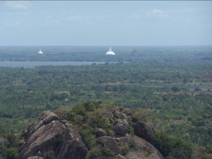 Stupas at Anuradhapura, a view from Mihintale: to the far left is Mirisavatiya stupa; at the center is Ruwanweliseya stupa; to the right, the blurred image is that of Jetavana Stupa.